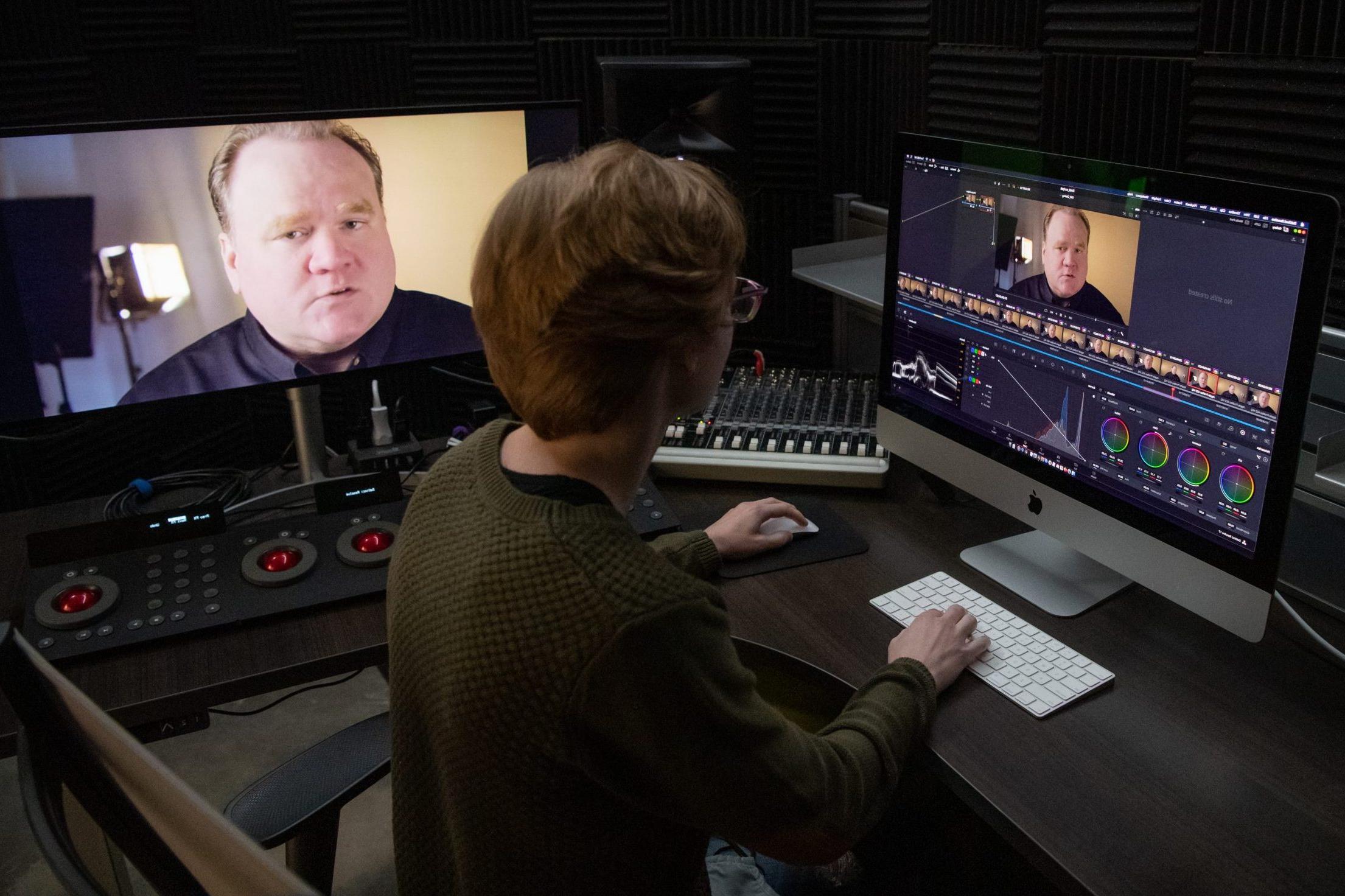 Student sitting at a desk editing video